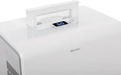 A close-up shot of the top of a white electronic device with a digital display and a handle.