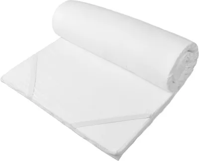 A white mattress topper rolled up on a white surface.