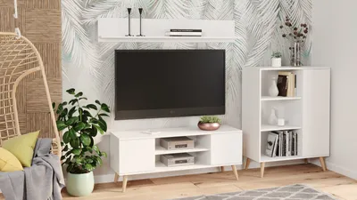 A modern living room setup featuring a TV stand, a television, a bookshelf, and a hanging chair.