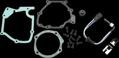 A collection of automotive engine parts, including gaskets, screws, and an electrical component, laid out against a black background.