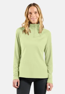 Frau trägt hellgrünen Odlo Essentials Ceramiwarm Mid Layer mit Halbreißverschluss und schwarzen Hosen