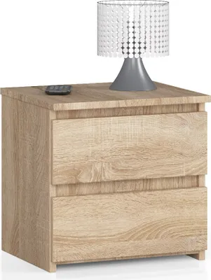 A wooden nightstand with two drawers and a lamp on top.