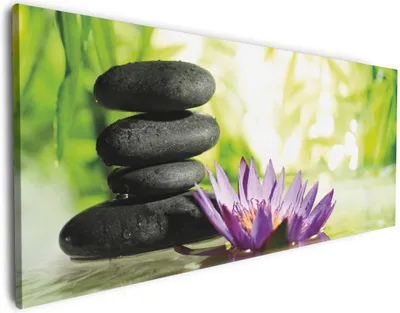 Produktbild von Wallario Premium Leinwandbild Steinstapel in schwarz mit Blumenblüte in lila in Größe 50 x 125 cm