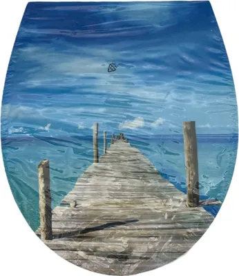 A wooden pier extending into a blue ocean under a cloudy sky.