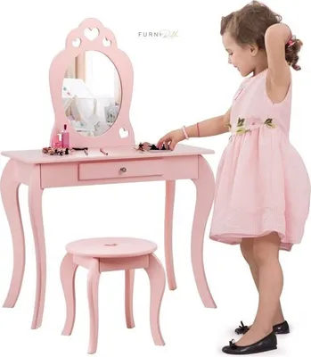 A young girl is playing with a pink toy vanity set.