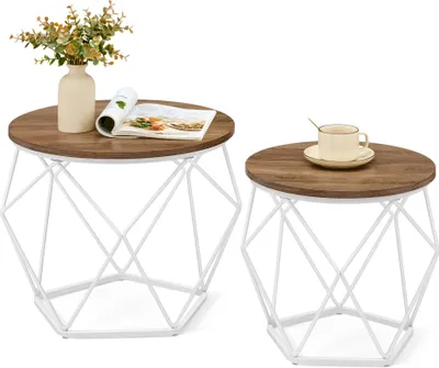 Two round coffee tables with wooden tops and white geometric bases are shown against a white background. One table has a vase with flowers and a magazine on it, while the other has a cup and saucer.
