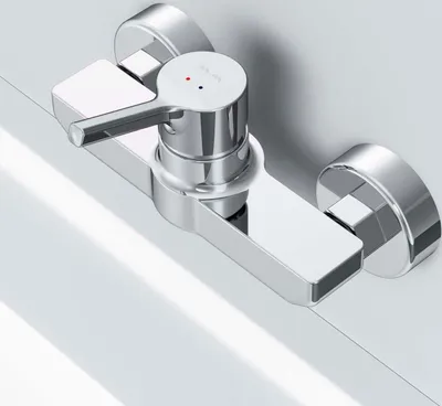 A close-up shot of a chrome shower faucet mounted on a white surface.