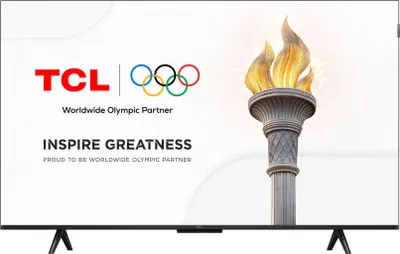 A television screen displaying a marketing image for TCL, a worldwide Olympic partner. The image features the TCL logo, the Olympic rings, a lit Olympic torch, and the slogan "INSPIRE GREATNESS."