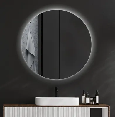 A modern bathroom vanity with a rectangular sink and a round illuminated mirror above it.