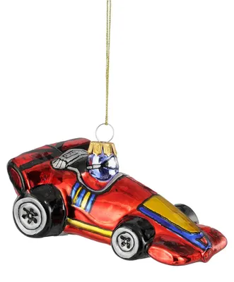 Ein glänzender Weihnachtsbaumanhänger aus Glas in Form eines roten Formel-1-Rennwagens mit gelben und blauen Akzenten.