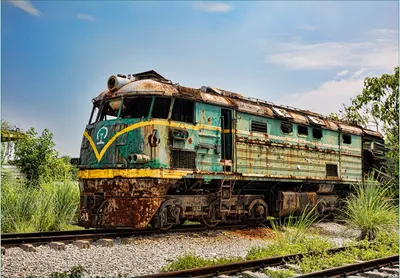 Produktbild von Wallario Fototapete Vliestapete, seidenmatte Oberfläche, einfache Verarbeitung, Größe 200 x 140 cm, Motiv Alte verrostete Lokomotive  auf einem Abstellgleis