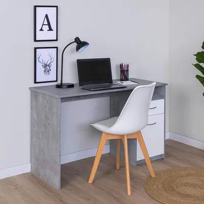 A modern desk setup with a laptop, lamp, and chair in a room.