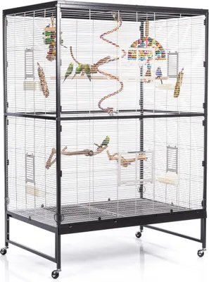 A large, multi-level bird cage with several birds and toys inside, set against a white background.
