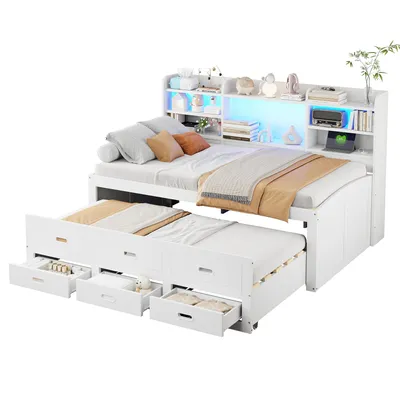A white daybed with a pull-out trundle bed and a headboard with shelves and LED lighting.