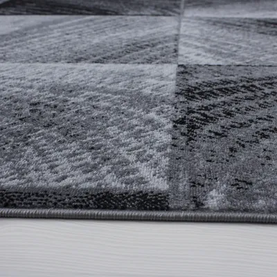 A close-up view of a gray and black checkered rug with a textured surface.