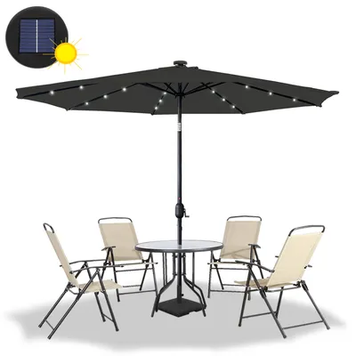 A dark gray patio umbrella with LED lights, a glass-topped table, and four beige folding chairs are arranged on a white background.