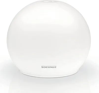 A white spherical aroma diffuser sits on a white surface.