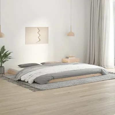 A bedroom scene with a low-profile wooden bed frame and bedding.