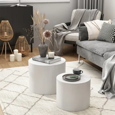 A cozy living room scene with a couch, armchair, coffee tables, and decorative items.