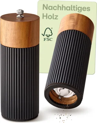 Two salt and pepper grinders are shown, one standing upright and the other tilted, with some ground pepper scattered below it. A green card with text and an FSC logo is in the background.