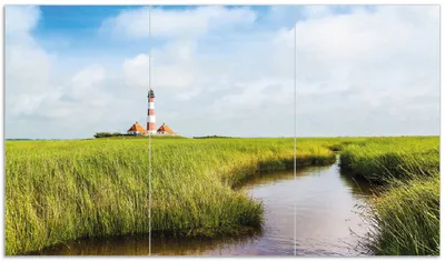 Produktbild von Wallario Herdabdeckplatte aus Glas, Größe 90 x 52 cm 3-teilig, Motiv Kleiner Bach durch Schilf auf dem Weg zum Leuchtturm