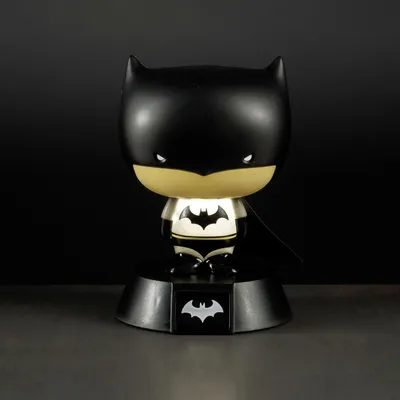A stylized Batman figurine lamp with a black base against a dark background.