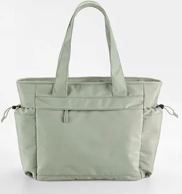A studio shot of a green tote bag against a white background.