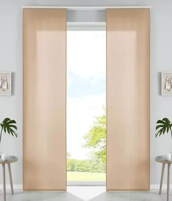 Two beige panel curtains are shown hanging in front of a window with a view of trees and sky.