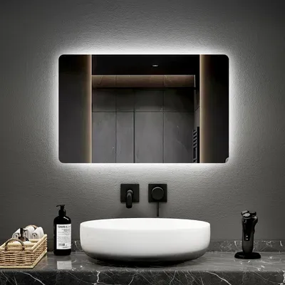 A modern bathroom vanity with a sink, mirror, and faucet.