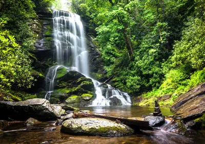 Produktbild von XXL Poster 100 x 70cm (S-834) Wasserfall im Gebirge Wasser fliesst über Steine in grünem Wald (Lieferung gerollt!)