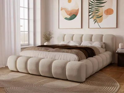 A bedroom scene with a large upholstered bed as the focal point.