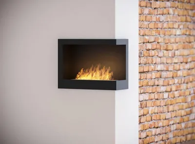 A modern black ethanol fireplace with flames is mounted on a white wall, adjacent to a brick wall.