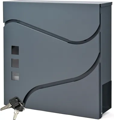 A gray mailbox with decorative cutouts and keys in the foreground.