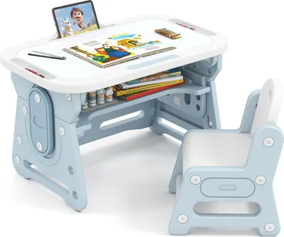 A child's desk and chair set, with books, art supplies, and a tablet displayed on the desk.