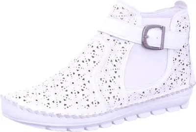 A white leather ankle boot with floral cutouts and a buckle.