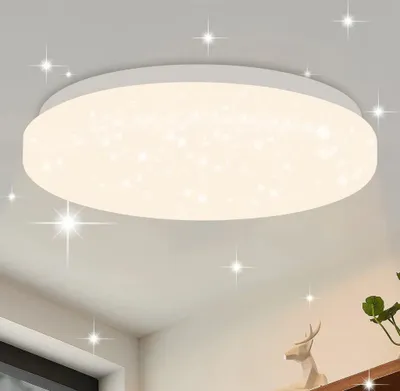 A modern, round LED ceiling light with a star-like pattern, mounted on a white ceiling.