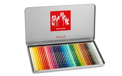 An open metal tin of Caran d'Ache Pablo colored pencils.