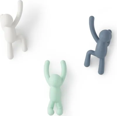 Three wall hooks shaped like climbing figures in different colors.