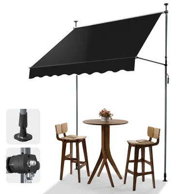 A black awning is set up over a small round table with two wooden bar stools.