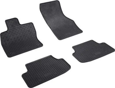 A set of four black rubber car floor mats arranged on a white background.