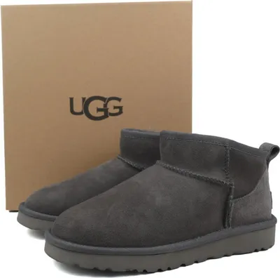 A pair of UGG boots are shown in front of their box.