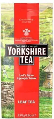 A bag of Yorkshire Tea with a rural landscape background.