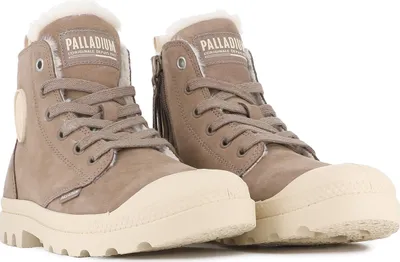 A pair of brown Palladium winter ankle boots with cream-colored soles and white fur lining, shown against a white background.