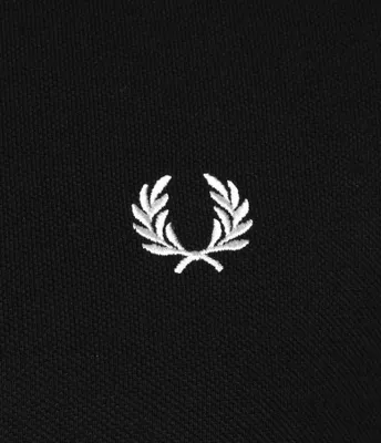 A close-up shot of a black fabric with a white embroidered laurel wreath logo.