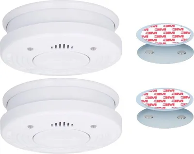 Two white smoke detectors and two magnetic mounting accessories are displayed against a white background.