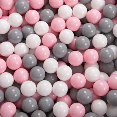 A close-up view of a pile of small, round balls in white, gray, and pink colors.