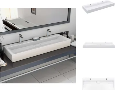 A modern bathroom sink with two faucets and a mirror above.