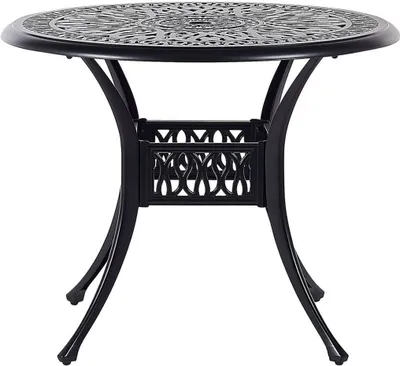 A black metal bistro table with an ornate, circular tabletop and curved legs.