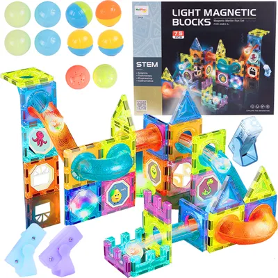 A collage of magnetic building blocks and accessories, including balls and light-up components, arranged to form a marble run.