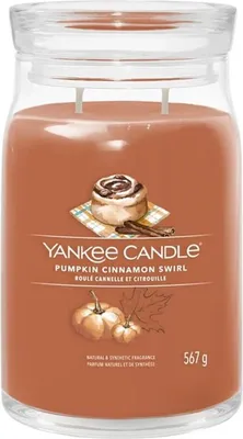 A Yankee Candle jar with a label showing a cinnamon roll, pumpkins, and cinnamon sticks.